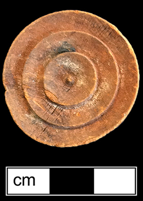 Checker game piece made of wood.  1.25" diameter, .25" tall, 3 concentric circles on both sides - from 18BC27, Feature 28.